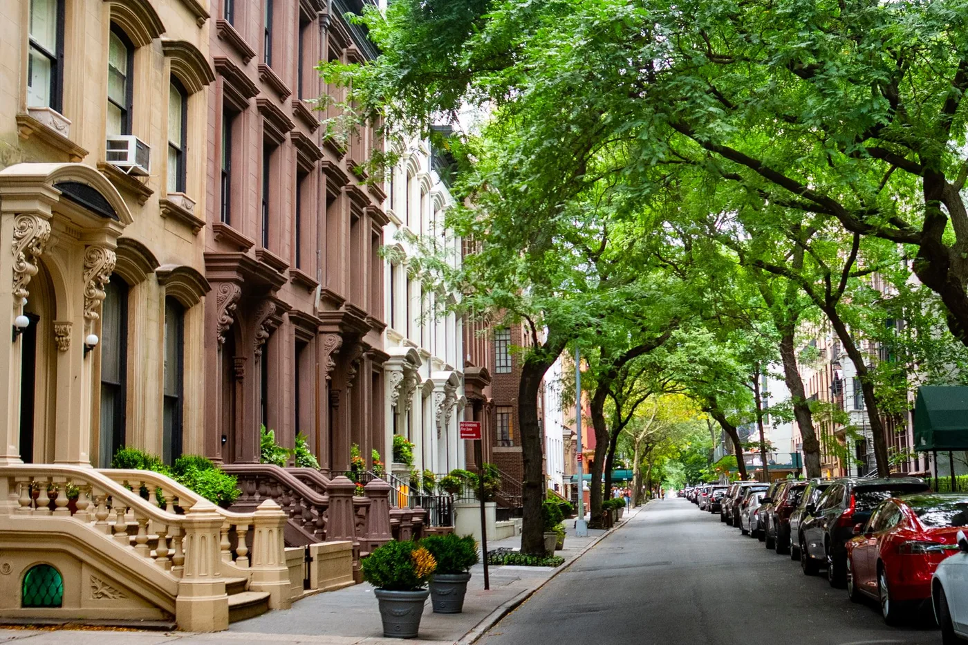 A tree-lined Brooklyn street with brownstone homes
