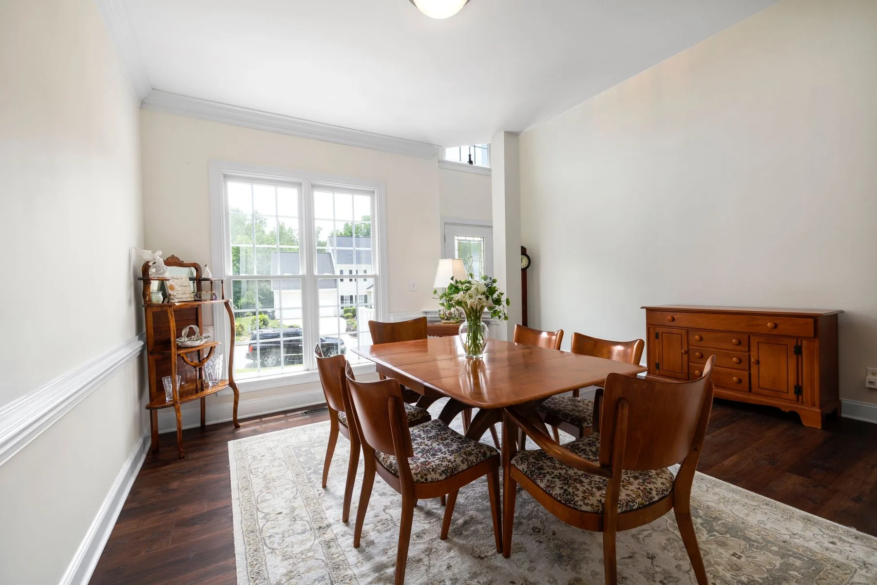 A wooden dining table in a bright room beside garden windows