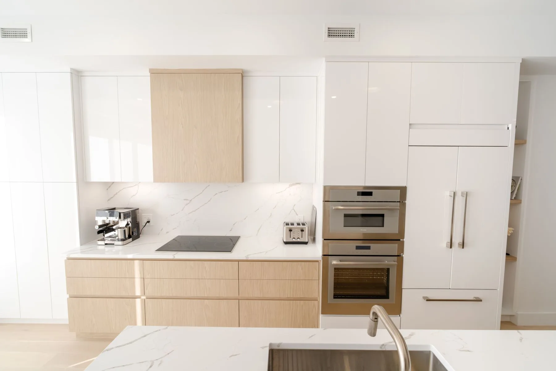 A welcoming kitchen with light wood cabinets and marble worktops
